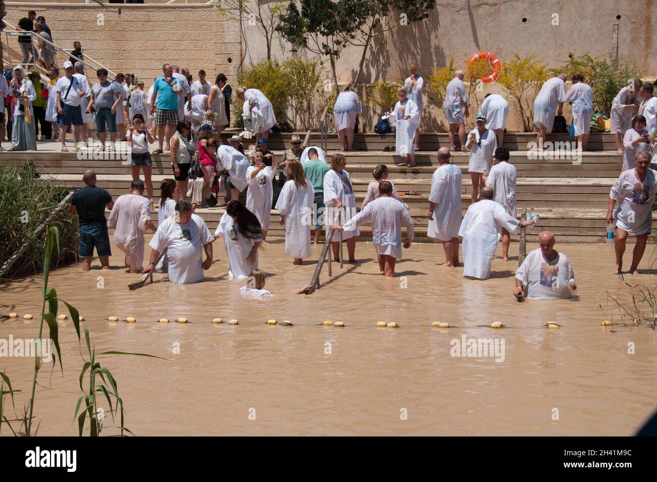 Cristiani che nuotano e sono battezzati nel fiume Giordano, Betania, Giordania, Medio Oriente Foto Stock