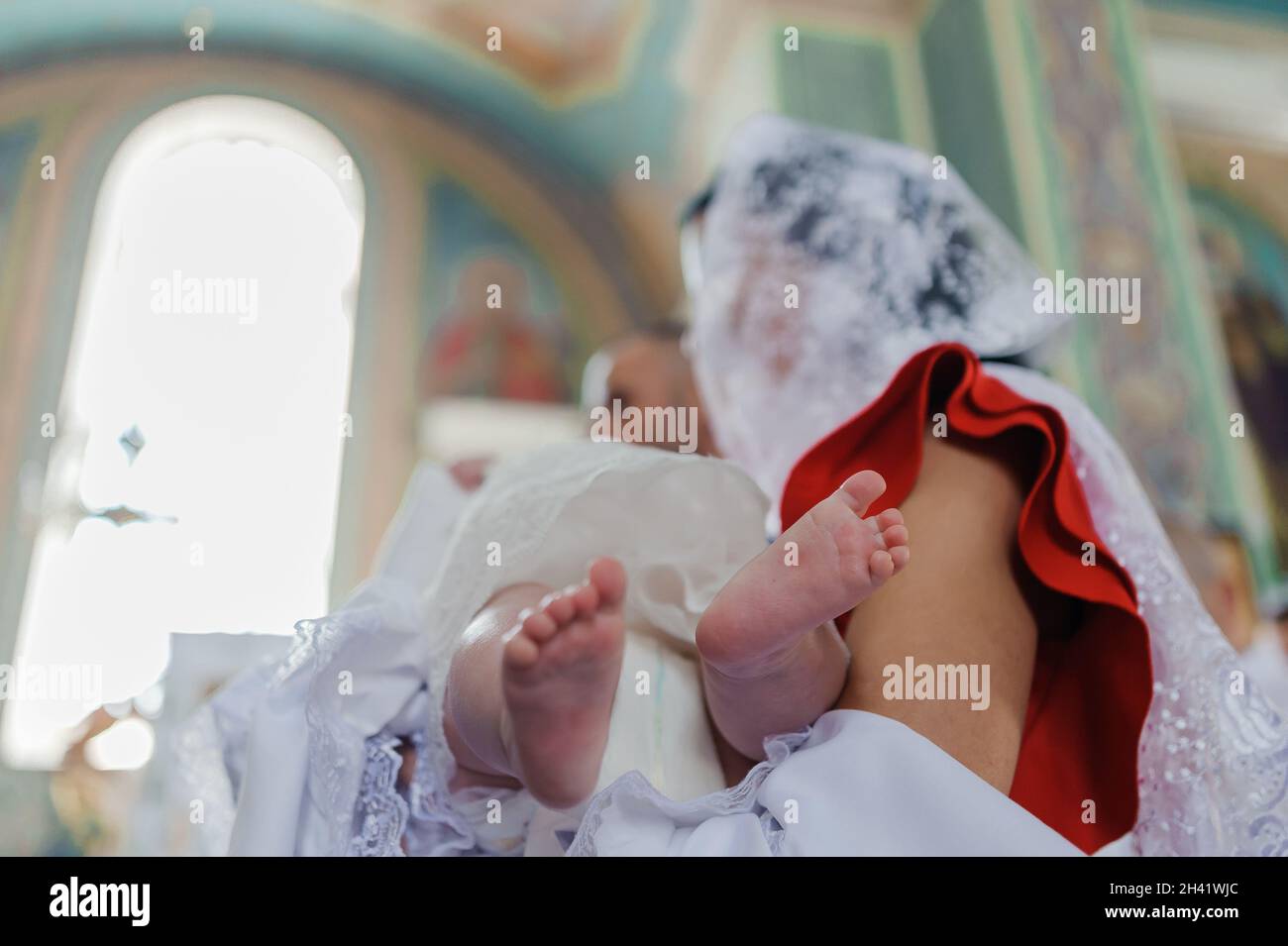 il bambino si inzappa sul braccio della madre Foto Stock