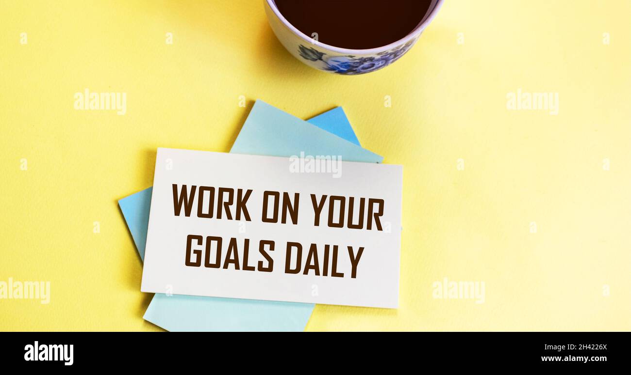 lavora sui tuoi obiettivi giornalieri - promemoria motivazionale, coffee cup adesivo scrittura, obiettivo impostazione, business e concetto di sviluppo personale Foto Stock