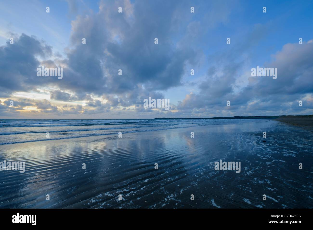 Un suggestivo paesaggio nuvoloso subito dopo il tramonto a Malltraeth Beach su Anglesey nel Galles del Nord, Regno Unito Foto Stock