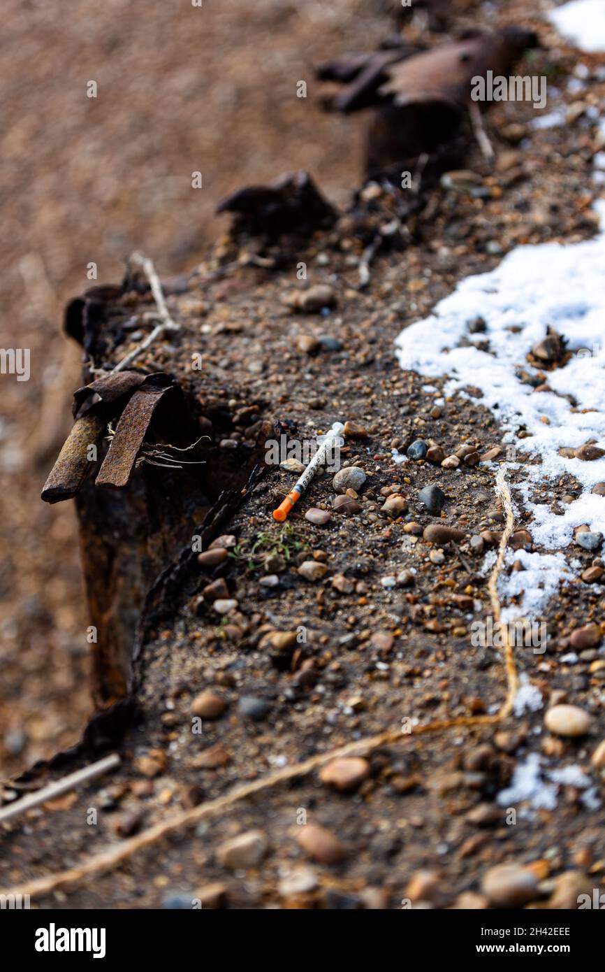 Una siringa usata che è stata scartata sul pavimento in una popolare spiaggia di Suffolk. Sembra che sia stato usato e lasciato lì da un utilizzatore di droga Foto Stock