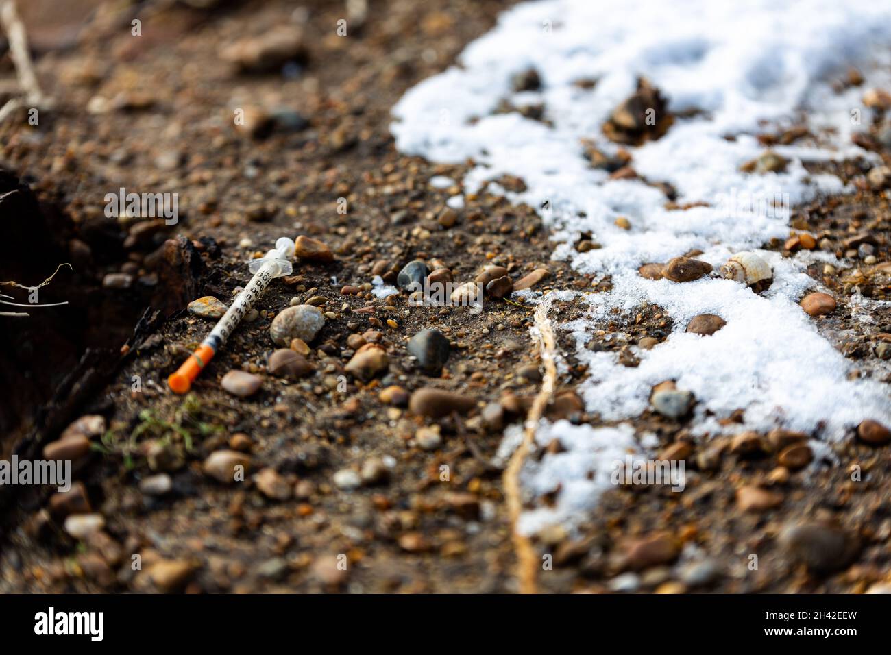 Una siringa usata che è stata scartata sul pavimento in una popolare spiaggia di Suffolk. Sembra che sia stato usato e lasciato lì da un utilizzatore di droga Foto Stock