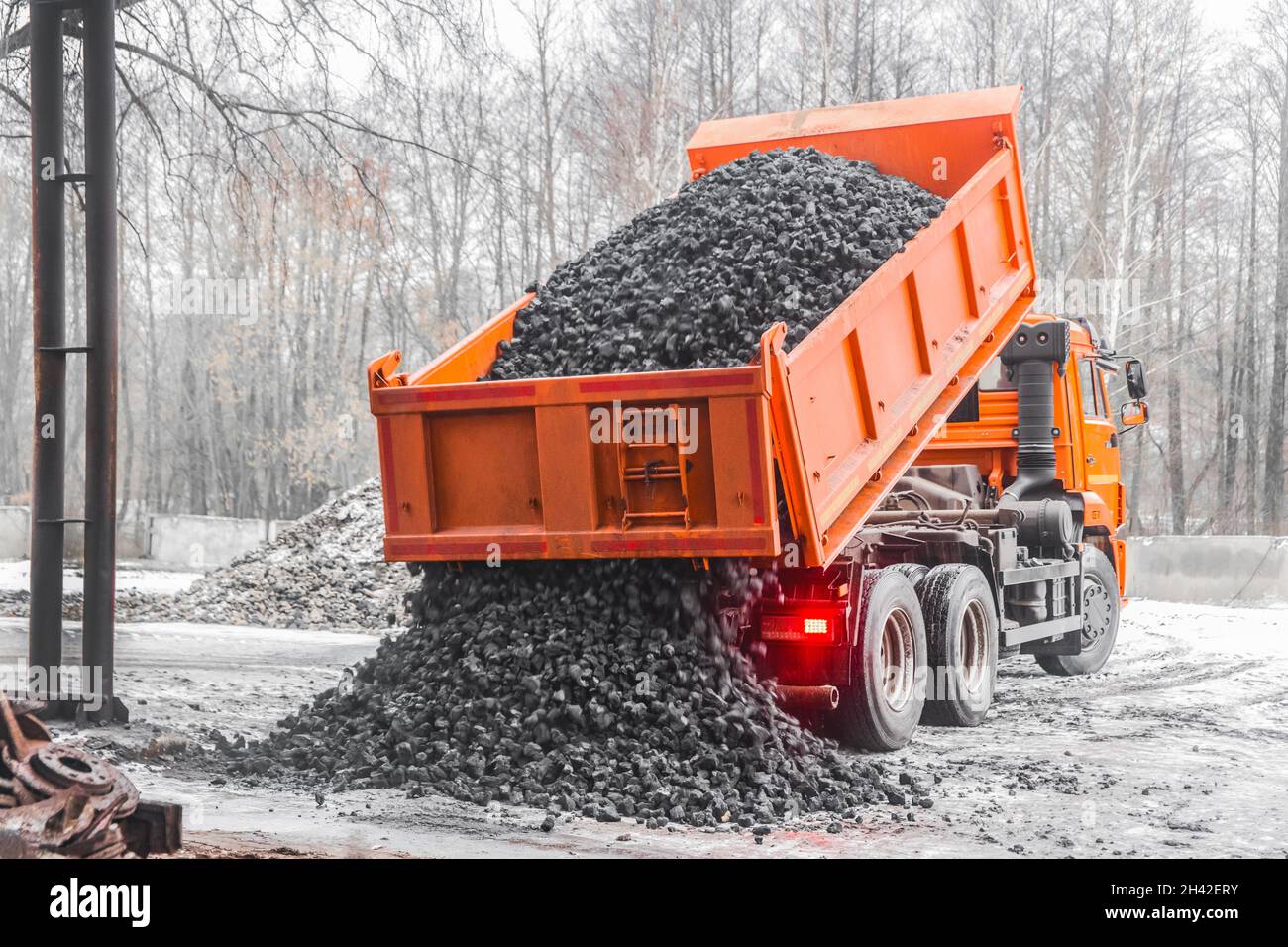 Il dumper di scarico nella zona industriale scarica il carbone da coke dalla carrozzeria. Foto Stock