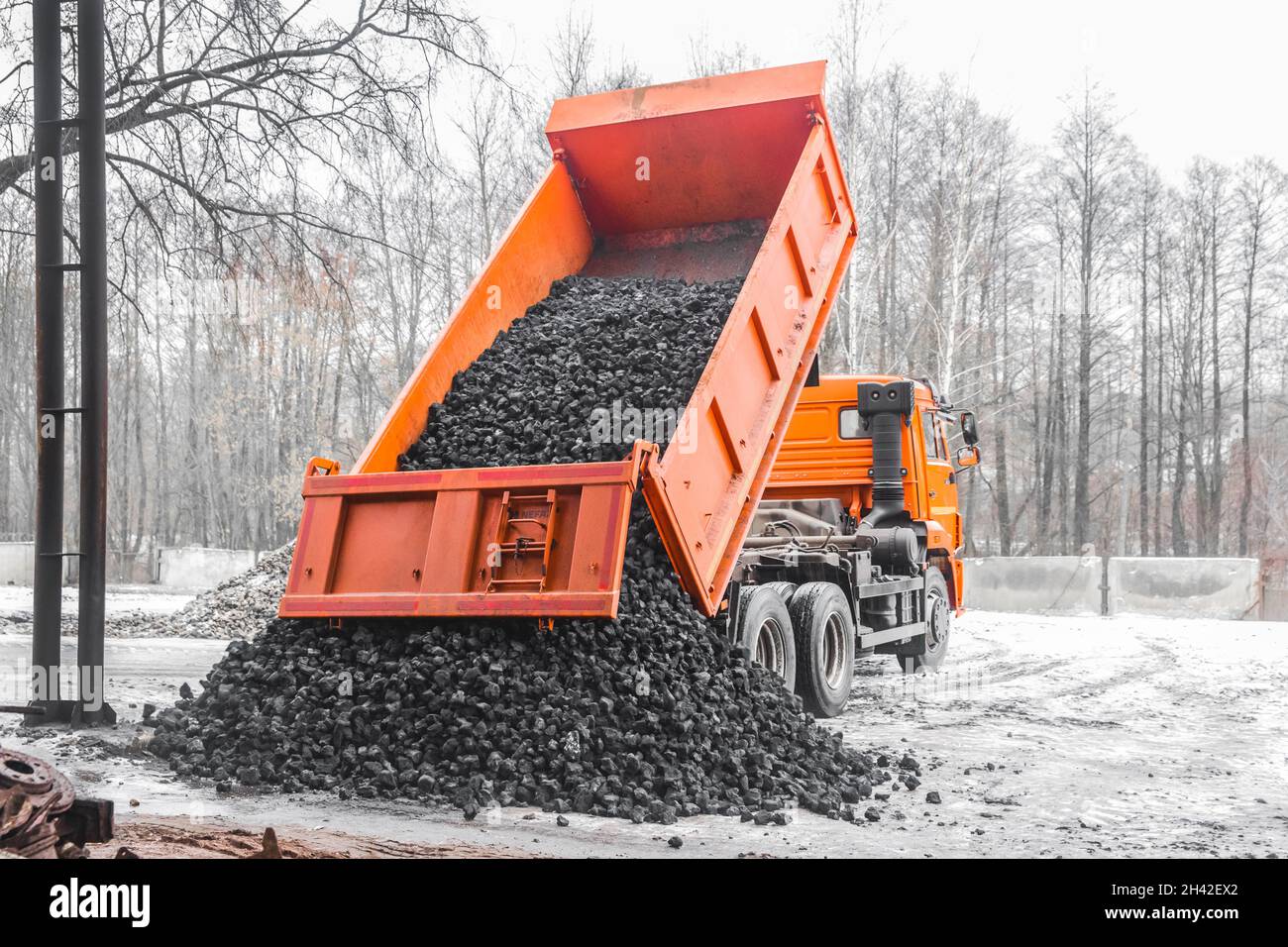 Il dumper di scarico nella zona industriale scarica il carbone da coke dalla carrozzeria. Foto Stock
