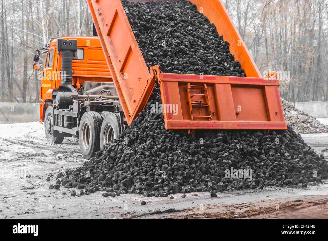 Il dumper di scarico nella zona industriale scarica il carbone da coke dalla carrozzeria. Foto Stock