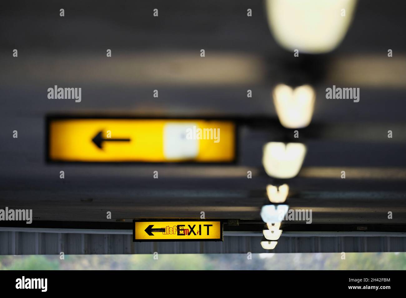 Interno di parcheggio auto a più piani con illuminazione e segnaletica sul soffitto Foto Stock