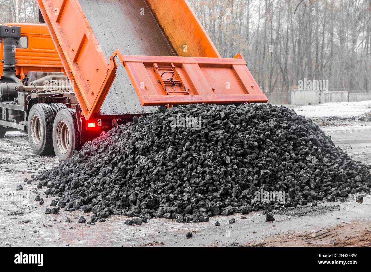 Il dumper di scarico nella zona industriale scarica il carbone da coke dalla carrozzeria. Foto Stock