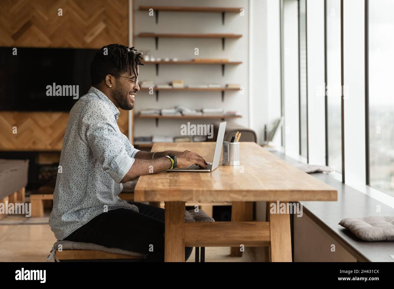 Felice giovane uomo misto da corsa che lavora al computer. Foto Stock