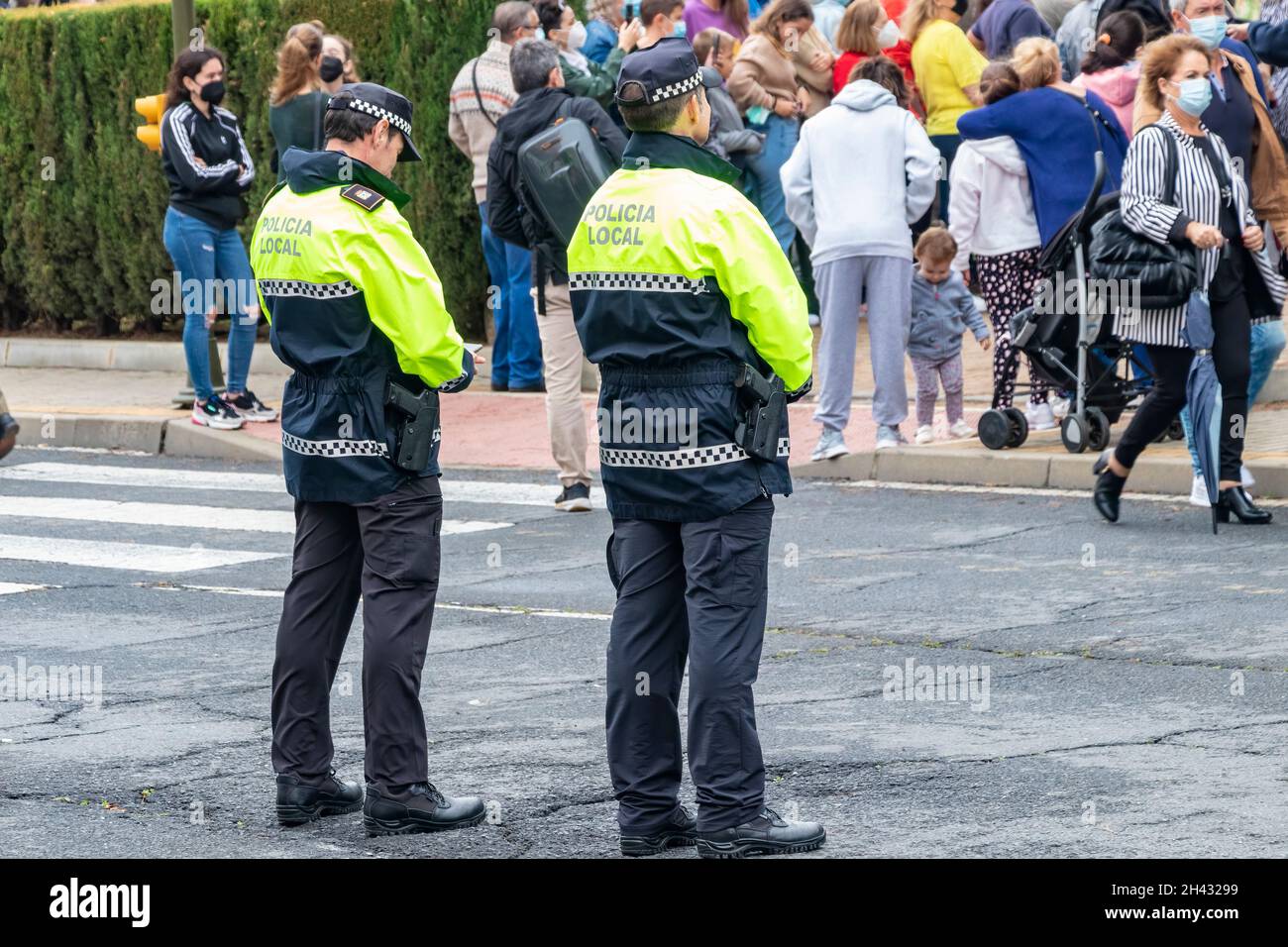 Huelva, Spagna - 30 ottobre 2021: Vista posteriore della polizia spagnola con l'emblema del logo 'polizia locale' su uniforme mantenere l'ordine pubblico nelle strade di Hue Foto Stock