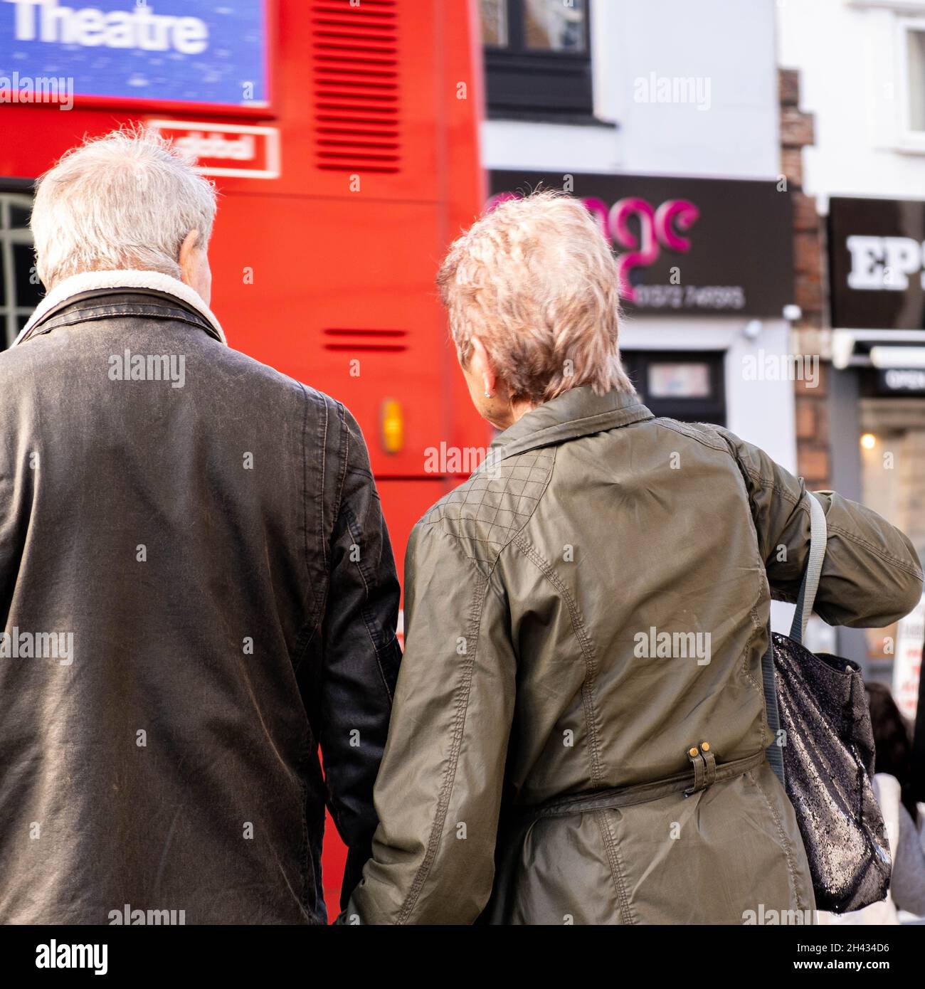 Epsom Surrey London UK, ottobre 31 2021, Senior Man and Woman Holding Hands Waiting to Cross A Busy High Street Road Foto Stock