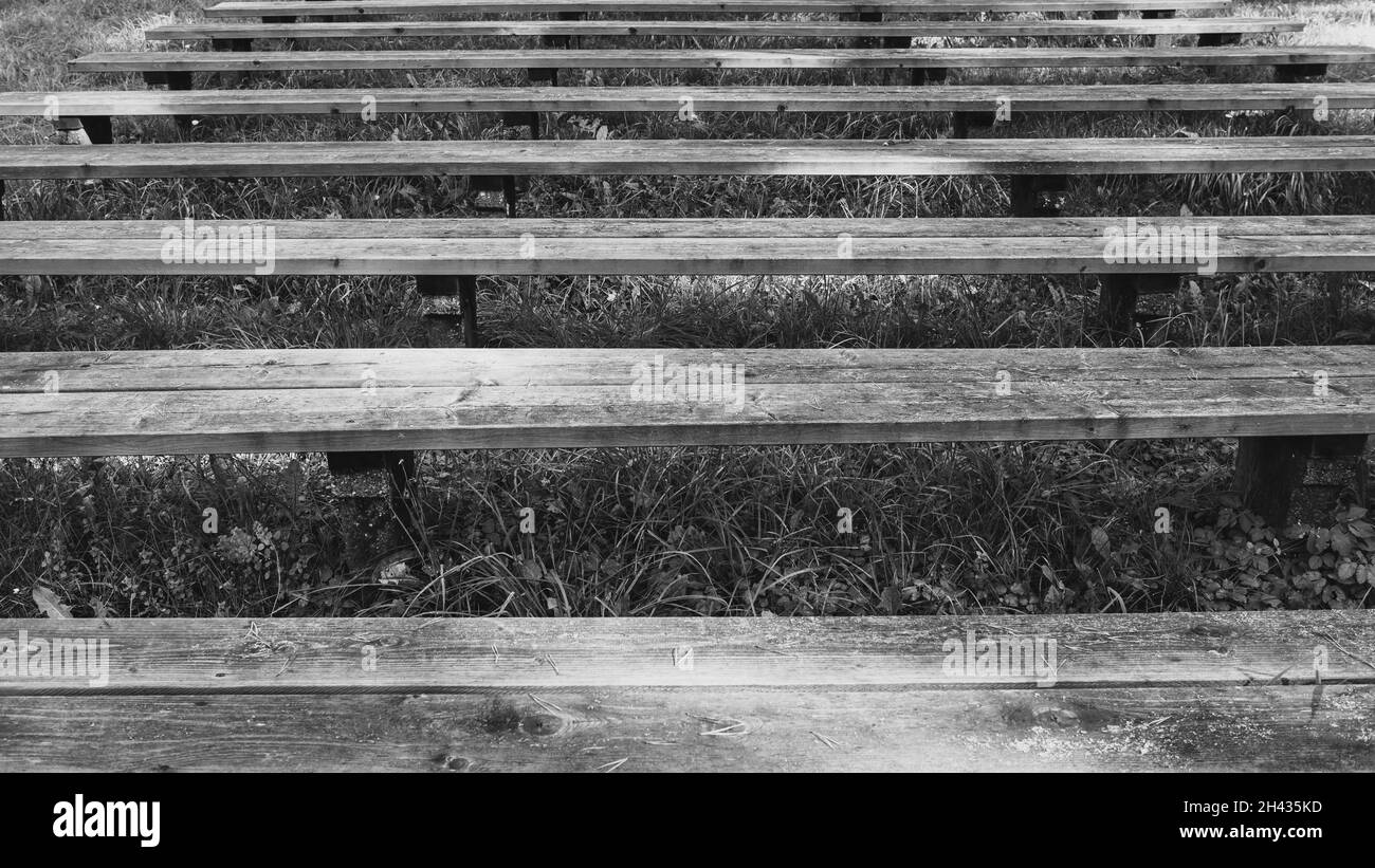 panca di legno con piedi di calcestruzzo in diverse file e sem hanno coltivato erba Foto Stock