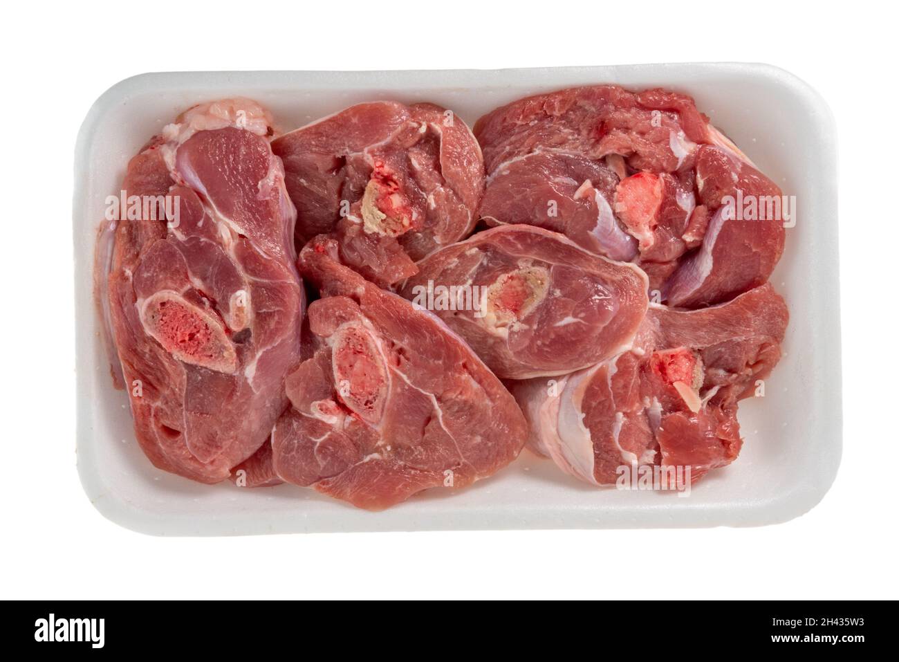 Buchi ossa di tacchino in contenitore di plastica, fette di zampe di tacchino in vassoio di polistirene alimentare isolato su sfondo bianco. Vista dall'alto Foto Stock