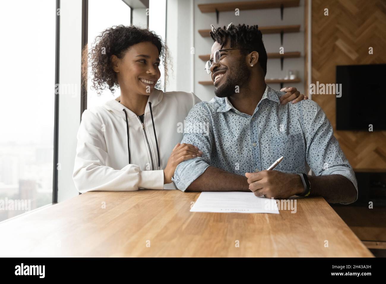 Felice giovane coppia afroamericana discutere contratto di firma. Foto Stock