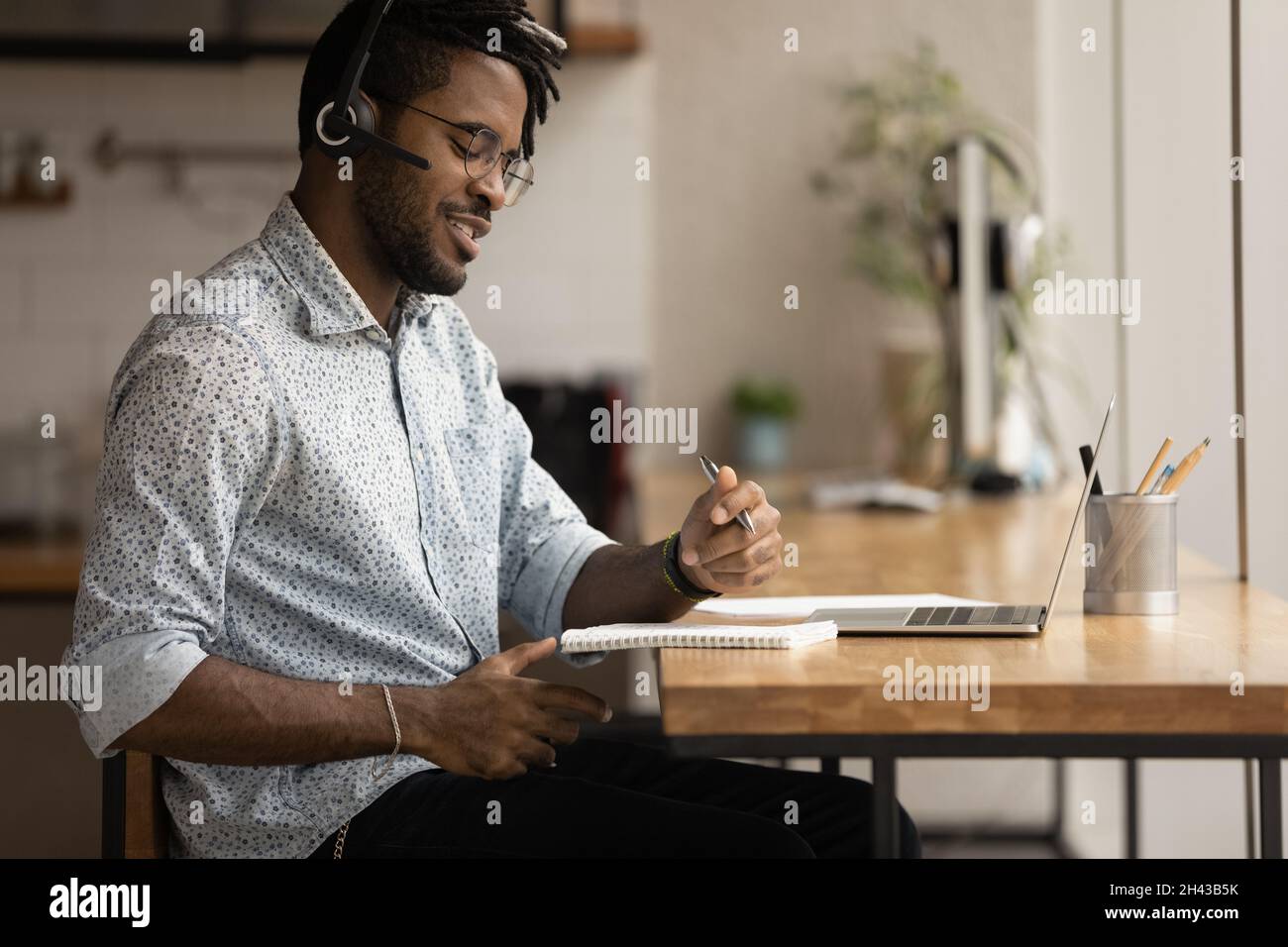 Sorridente giovane afroamericano che studia online. Foto Stock