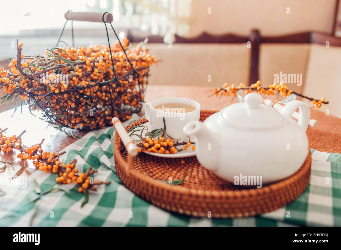 Tè con frutti di bosco di buckhorn serviti in tazza e bollitore su vassoio bevanda calda sana per freddo autunno e inverno giorni Foto Stock