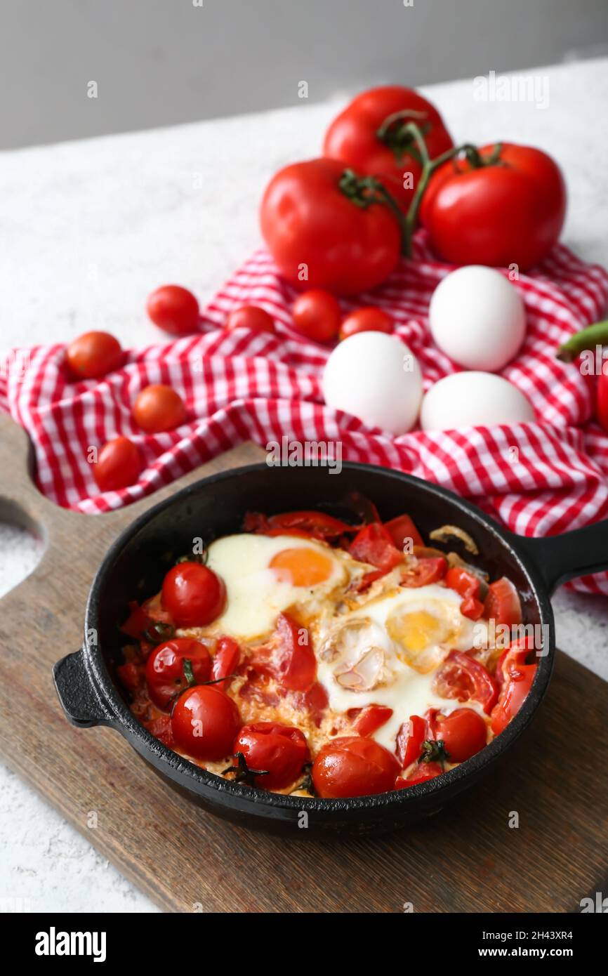 Padella con il gustoso Shakshouka sul tavolo Foto Stock