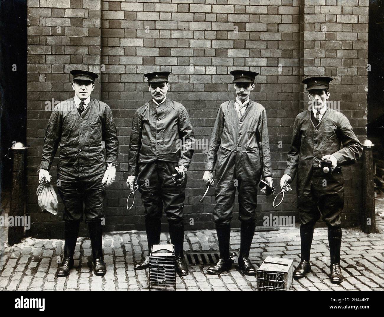 Liverpool Port Sanitary Authority Rat-Catchers vestiti di protezione con trappole e attrezzature, Liverpool, Inghilterra. Fotografia, 1900/1920. Foto Stock