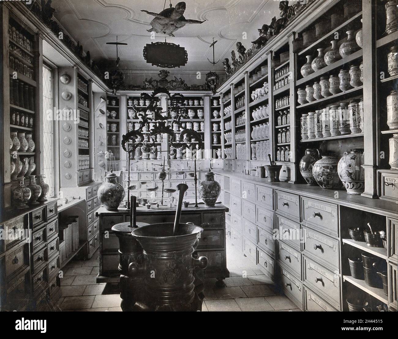 Un negozio di apothecary tedesco del XVII secolo con vasi ornati della farmacia, grandi mortai di metallo e una tartaruga ripiena appesa al soffitto; ricreata per il Museo Nazionale Tedesco di Nürnberg. Fotografia di Christof Müller. Foto Stock