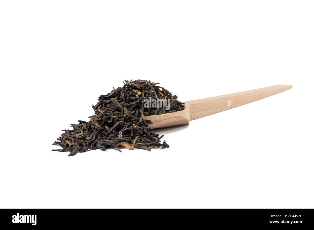 tè nero yunnan su cucchiaio di legno isolato su sfondo bianco. Foto Stock