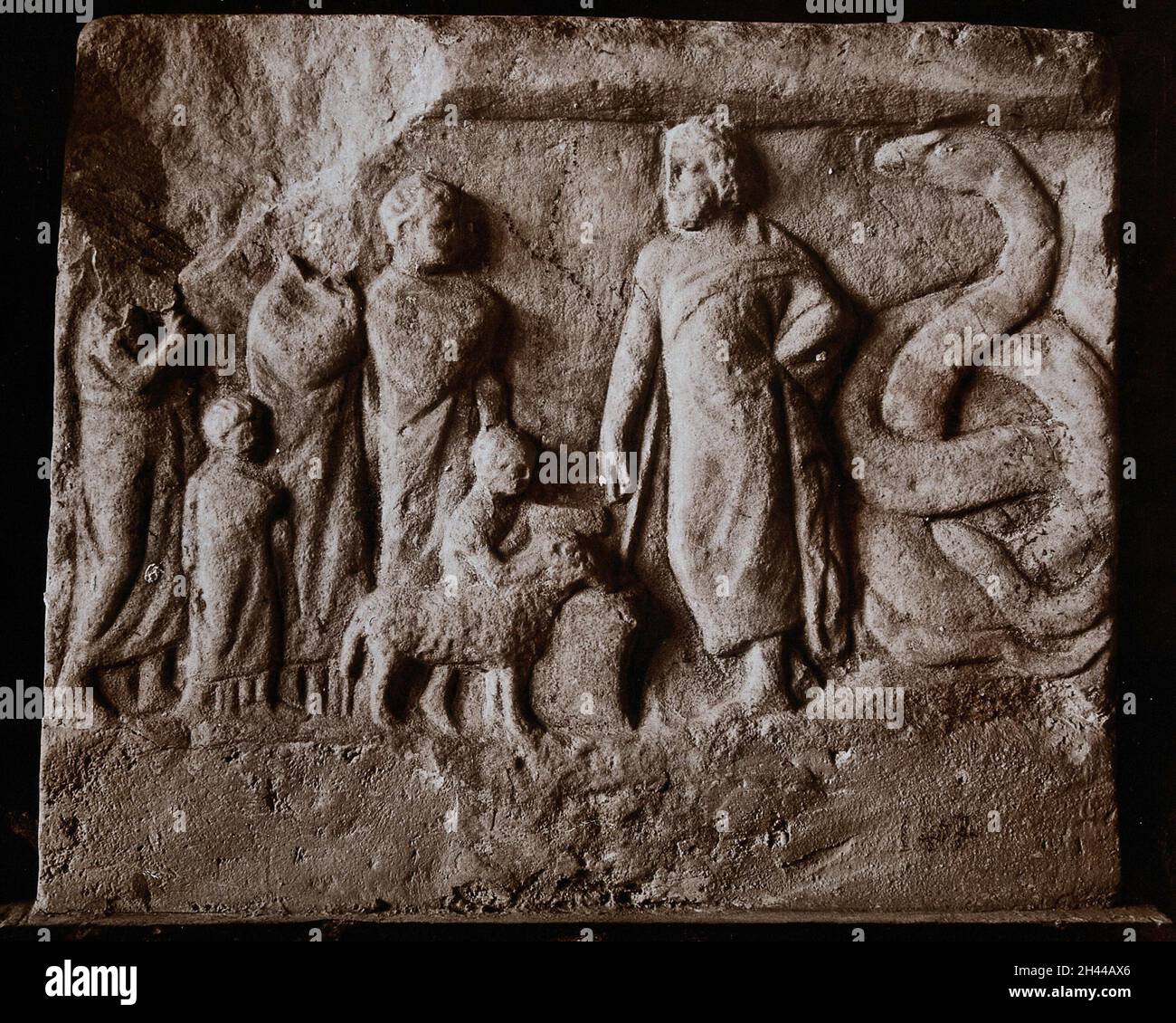 Aesculapius, il dio greco della guarigione, ricevendo pazienti con il serpente al suo fianco. Fotografia, 19--, di un bassorilievo in pietra. Foto Stock