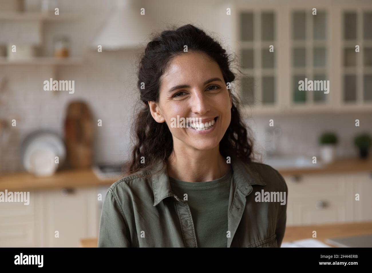 Headshot ritratto giovane ispanica donna sorridente guardando la macchina fotografica Foto Stock