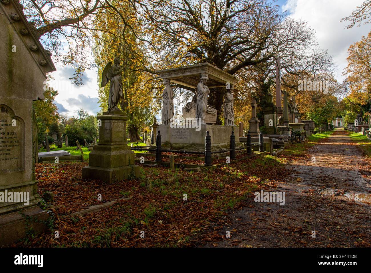 Monumenti funerari in pietra del XIX secolo, uno dei quali presenta i Caryatidi al Cimitero Verde Kensal al sole d'autunno Foto Stock