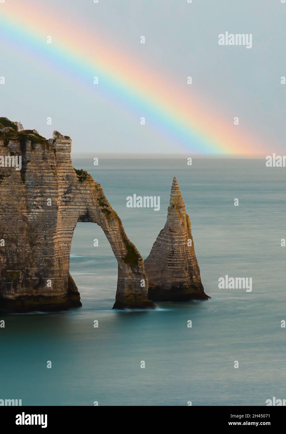 Étretat è meglio conosciuta per le sue scogliere di gesso, tra cui tre archi naturali e una formazione appuntita chiamata Aiguille o l'ago Foto Stock