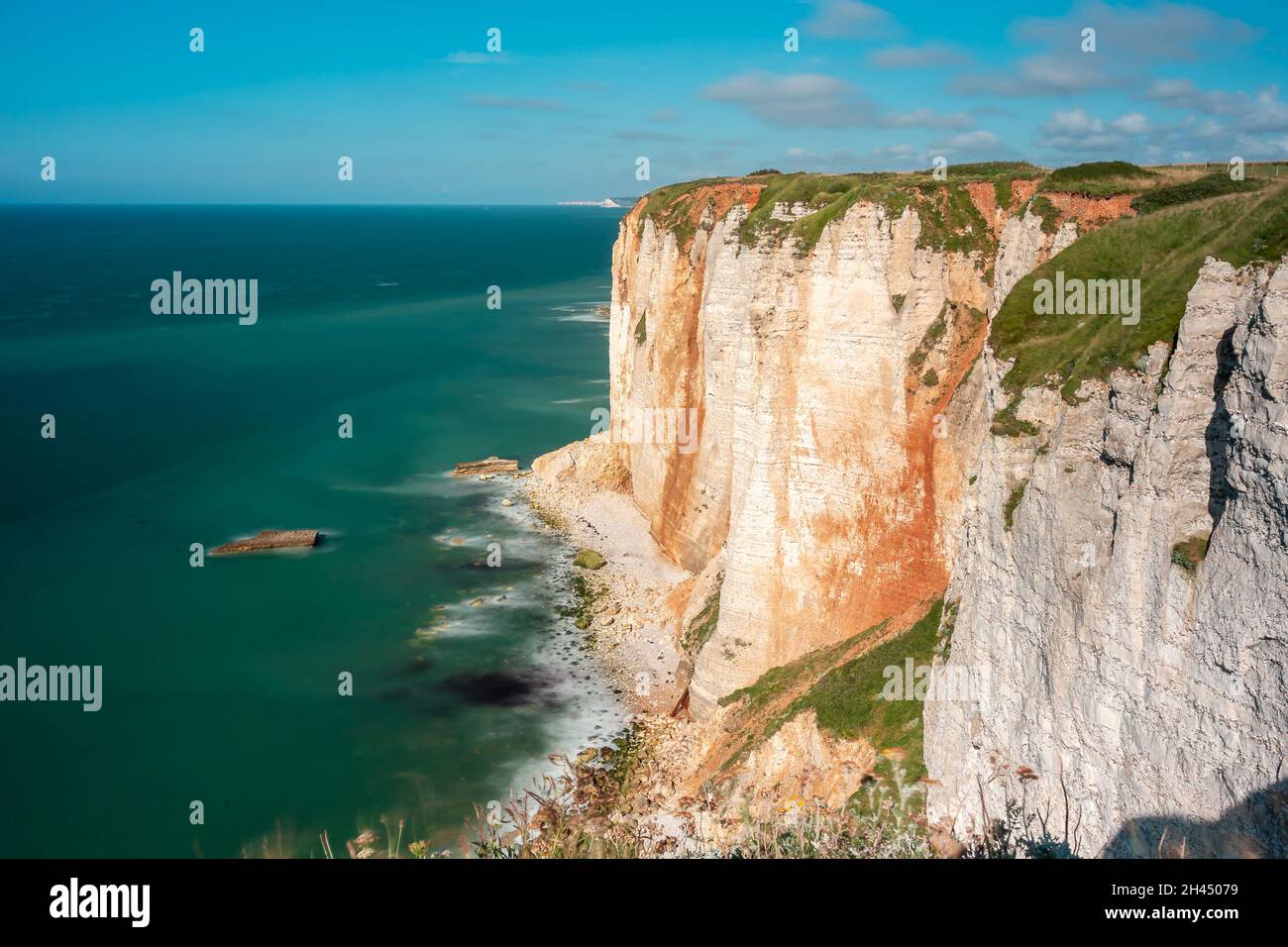 Etretat è meglio conosciuta per le sue scogliere di gesso, tra cui tre archi naturali e una formazione appuntita chiamata Aiguille o l'ago Foto Stock