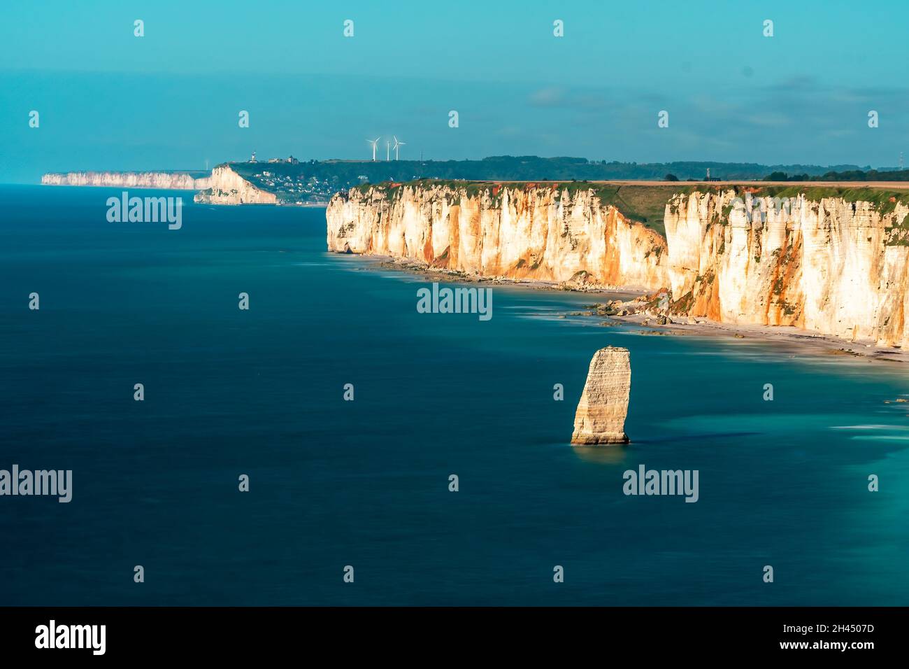 Etretat è meglio conosciuta per le sue scogliere di gesso, tra cui tre archi naturali e una formazione appuntita chiamata Aiguille o l'ago Foto Stock