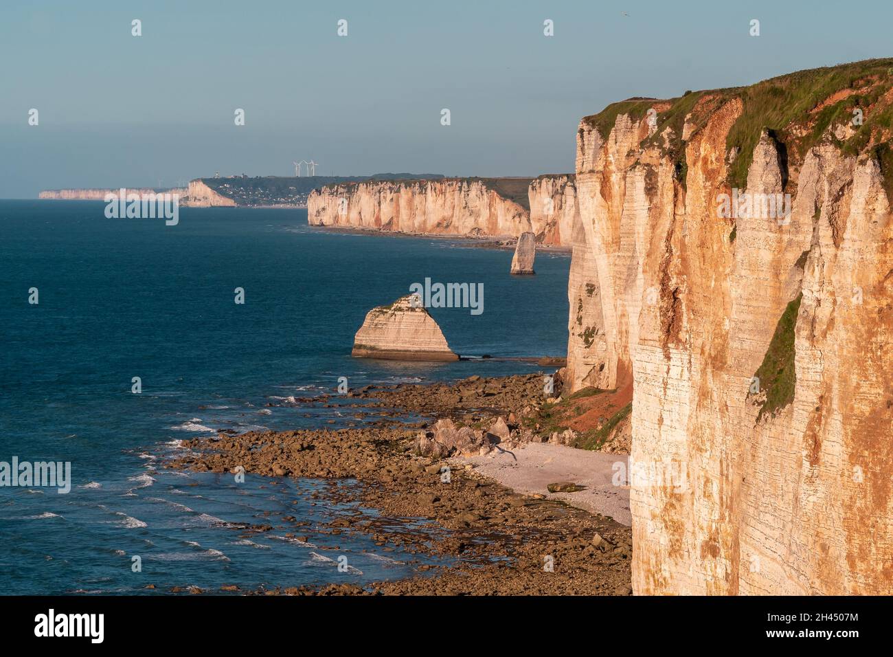 Etretat è meglio conosciuta per le sue scogliere di gesso, tra cui tre archi naturali e una formazione appuntita chiamata Aiguille o l'ago Foto Stock