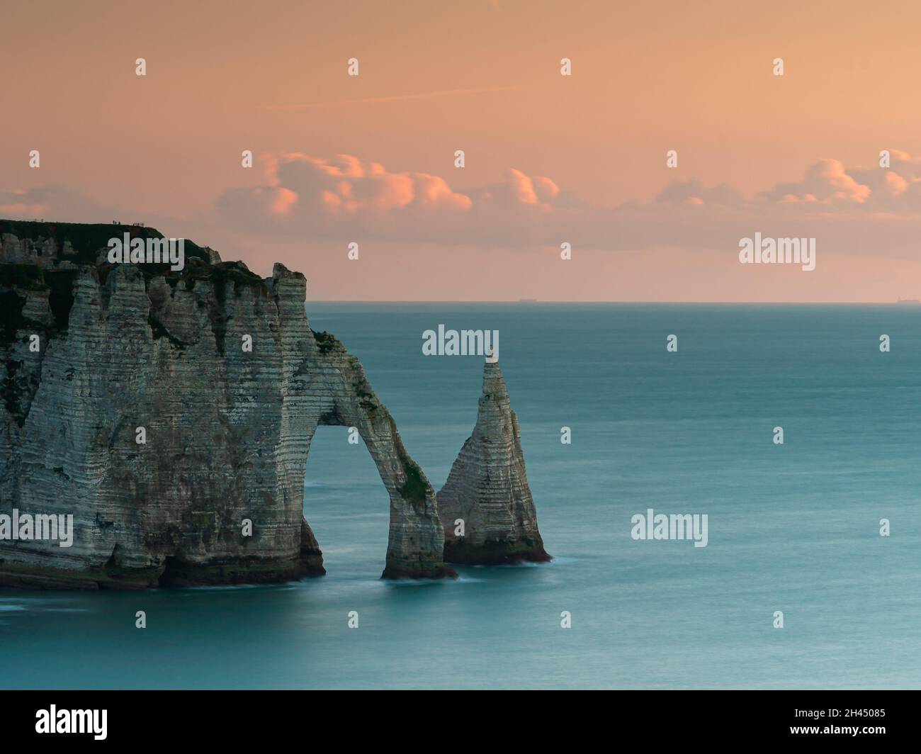 Etretat è meglio conosciuta per le sue scogliere di gesso, tra cui tre archi naturali e una formazione appuntita chiamata Aiguille o l'ago Foto Stock