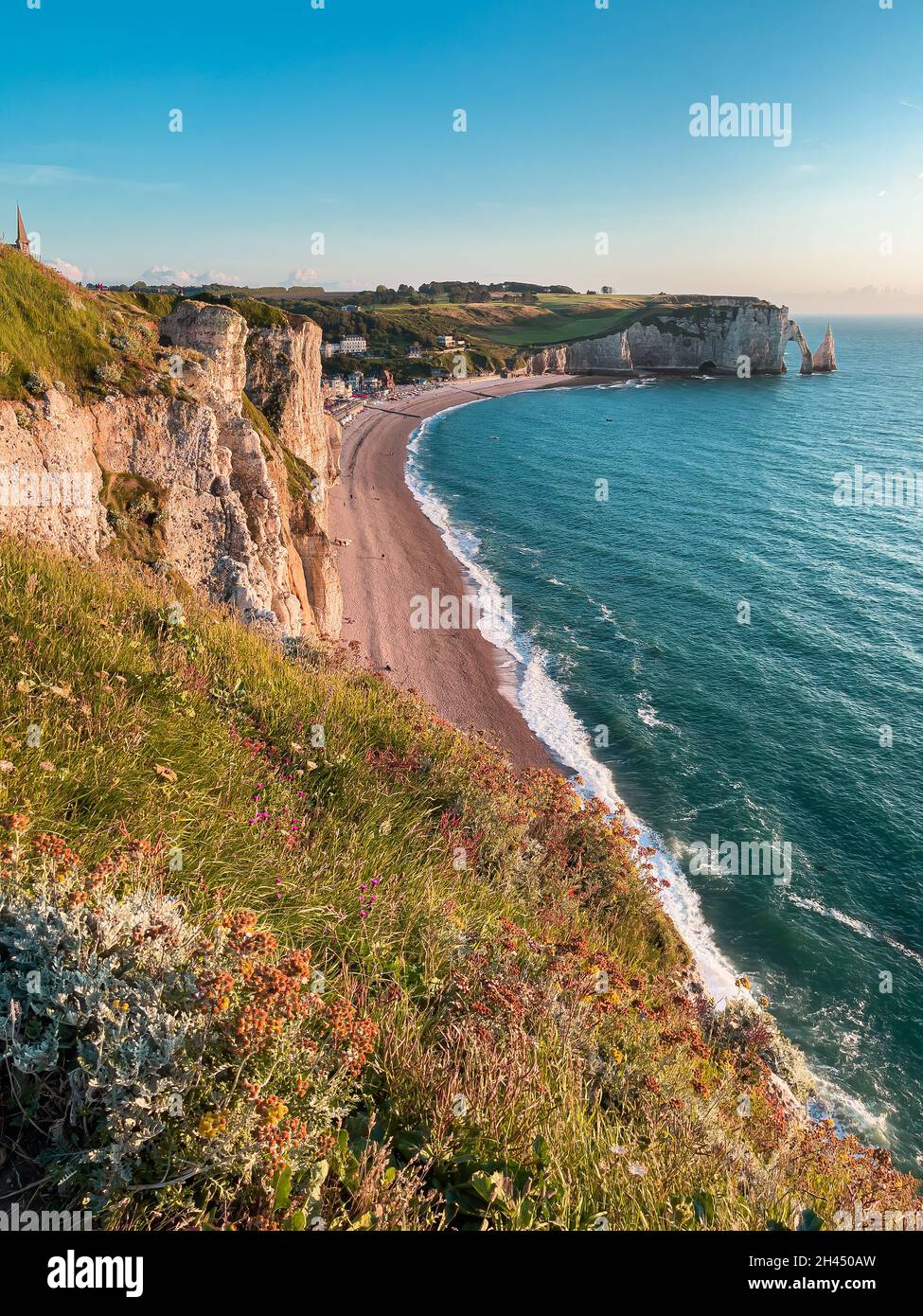 Etretat è meglio conosciuta per le sue scogliere di gesso, tra cui tre archi naturali e una formazione appuntita chiamata Aiguille o l'ago Foto Stock