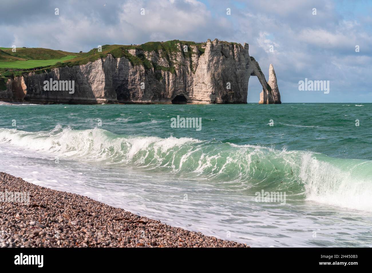 Etretat è meglio conosciuta per le sue scogliere di gesso, tra cui tre archi naturali e una formazione appuntita chiamata Aiguille o l'ago Foto Stock