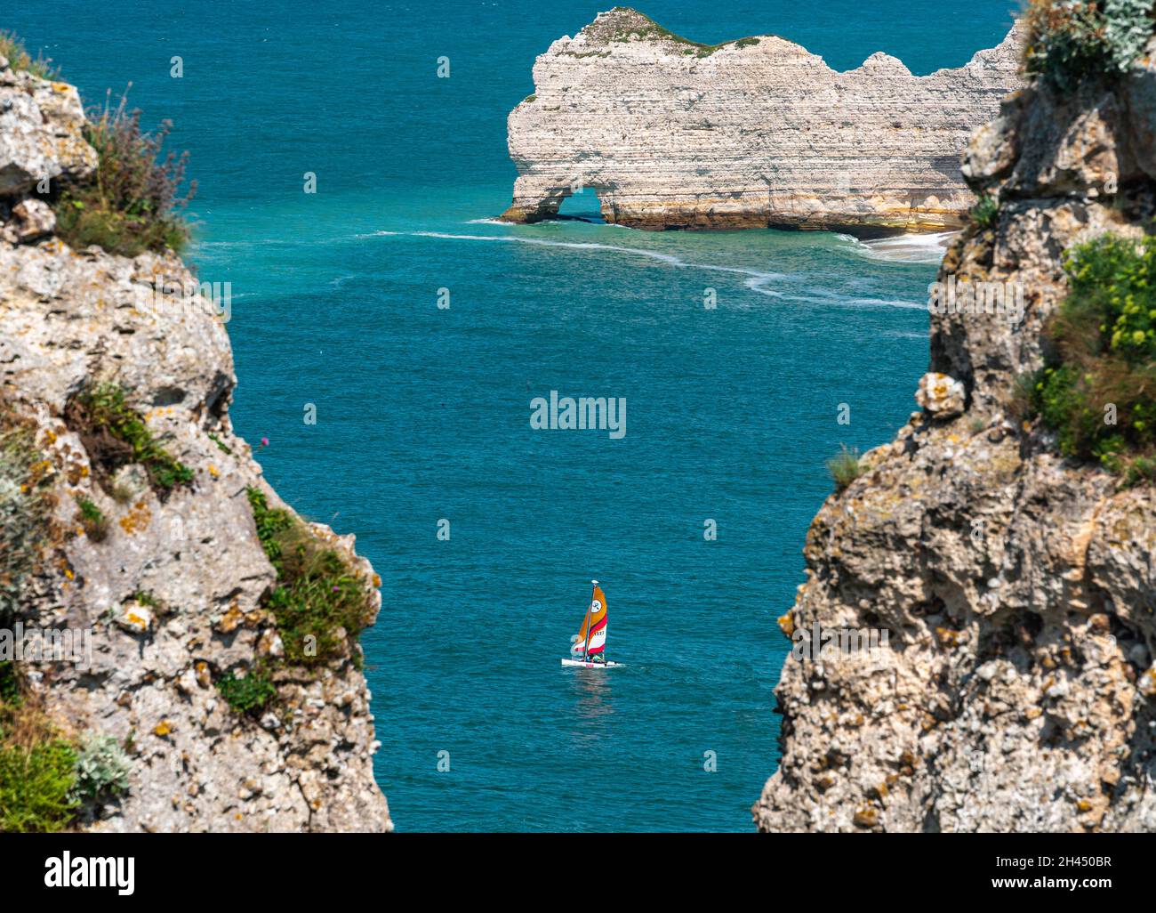Etretat, Francia - 31 luglio 2021: la barca a vela naviga tra le scogliere di Etretat sull'Oceano Atlantico in Normandia Foto Stock