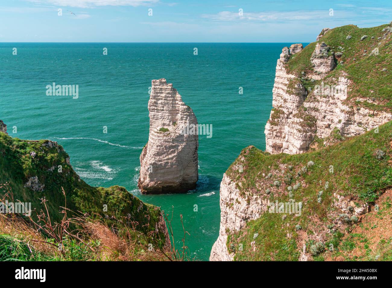 Etretat è meglio conosciuta per le sue scogliere di gesso, tra cui tre archi naturali e una formazione appuntita chiamata Aiguille o l'ago Foto Stock