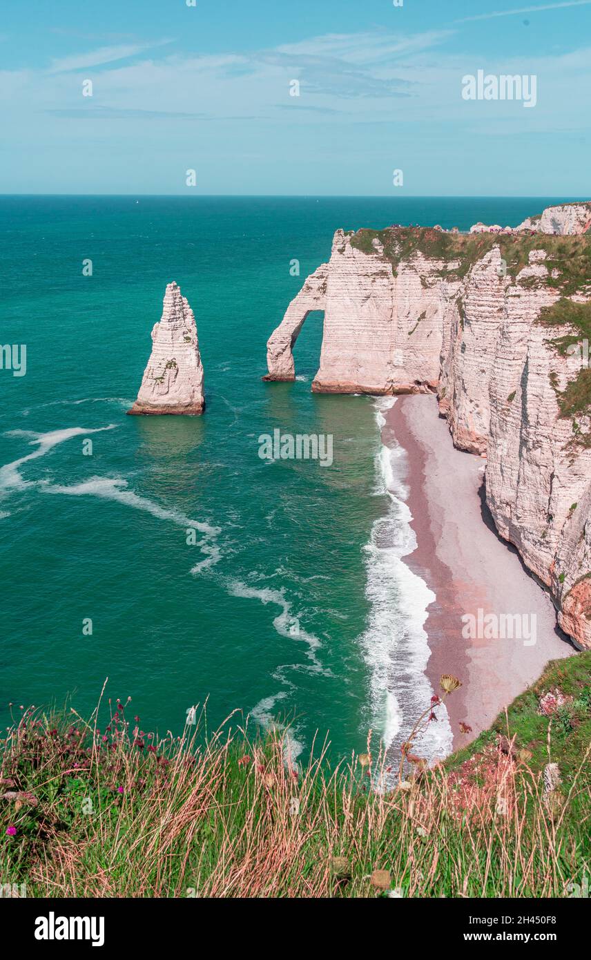 Etretat è meglio conosciuta per le sue scogliere di gesso, tra cui tre archi naturali e una formazione appuntita chiamata Aiguille o l'ago Foto Stock