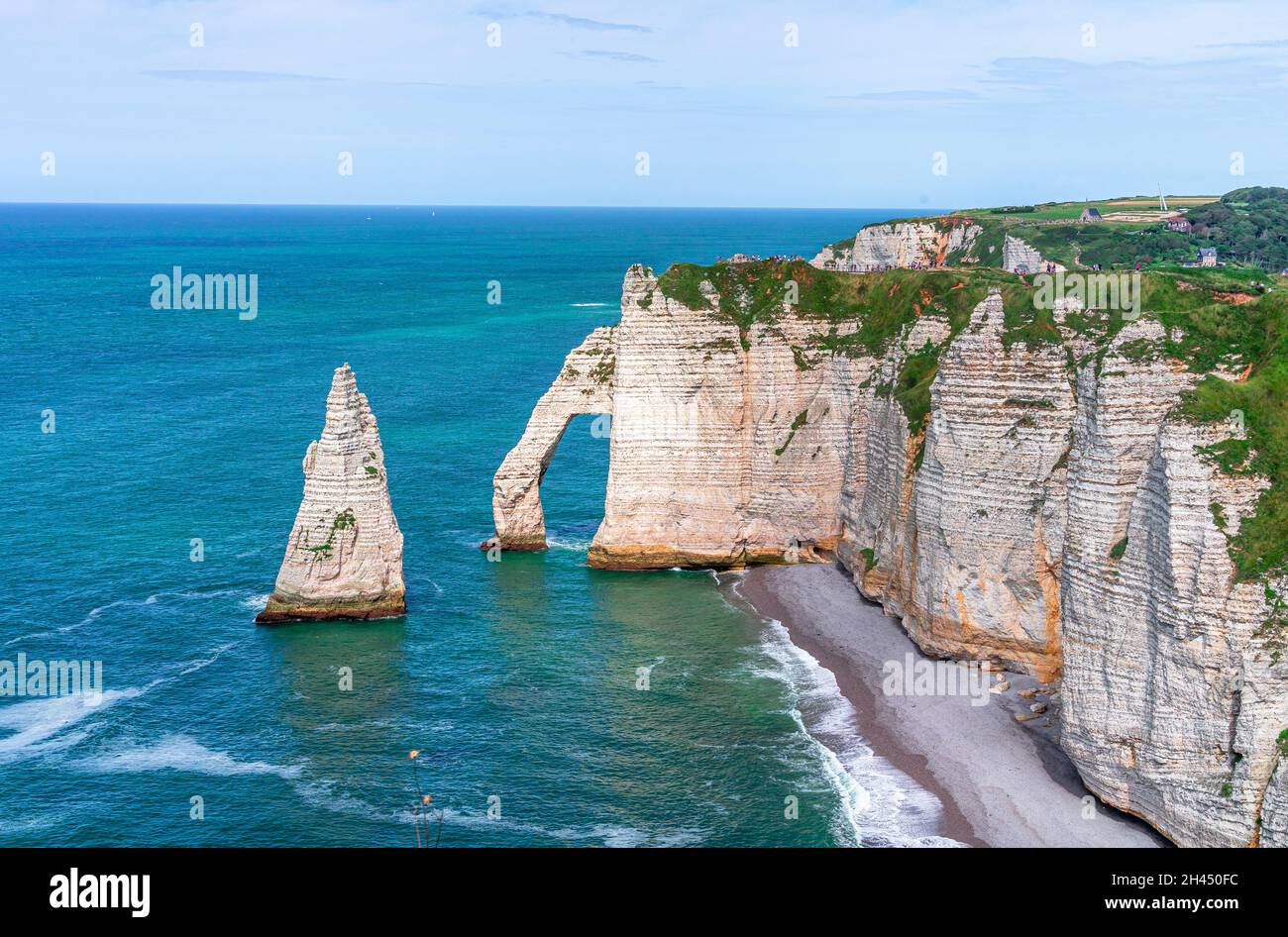 Etretat è meglio conosciuta per le sue scogliere di gesso, tra cui tre archi naturali e una formazione appuntita chiamata Aiguille o l'ago Foto Stock