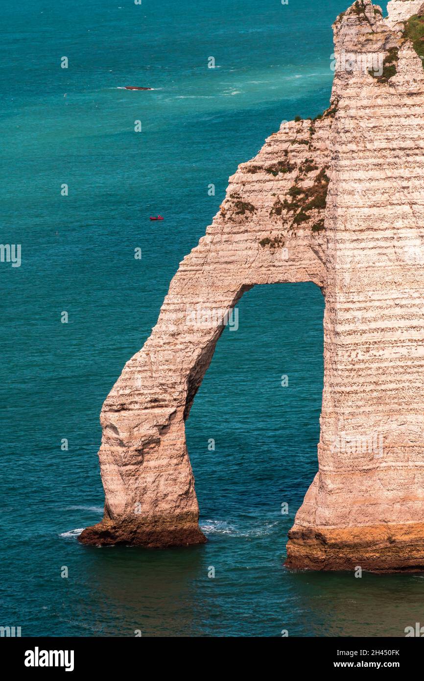 Etretat è meglio conosciuta per le sue scogliere di gesso, tra cui tre archi naturali e una formazione appuntita chiamata Aiguille o l'ago Foto Stock