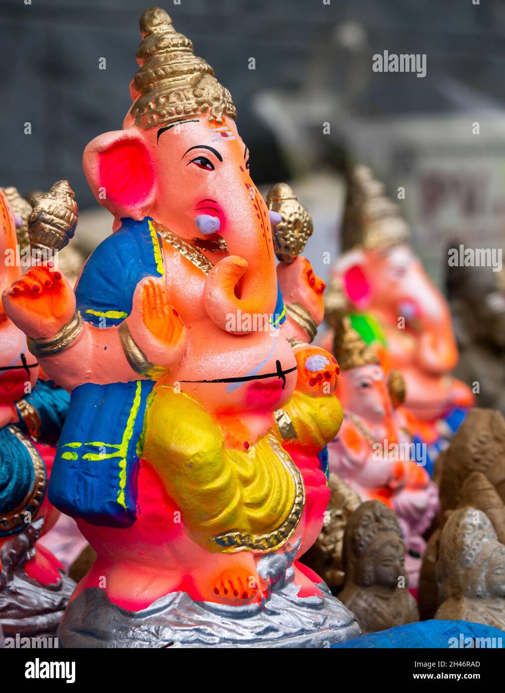 Scatto verticale di una scultura Ganesha colorata su sfondo sfocato Foto Stock