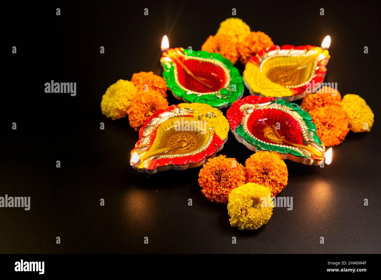 Lampade Diwali tradizionali in argilla Diya decorate con fiori marigolenti su sfondo scuro Foto Stock