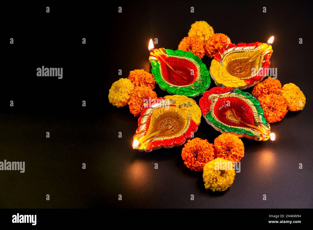 Lampade Diwali tradizionali in argilla Diya decorate con fiori marigolenti su sfondo scuro Foto Stock
