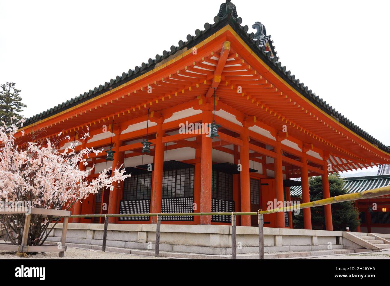 Vista dell'esterno dell'edificio con soffitto, colonna e lanterna al Santuario Heian di Kyoto, Giappone, con sfondo cielo luminoso. Nessuna gente. Foto Stock