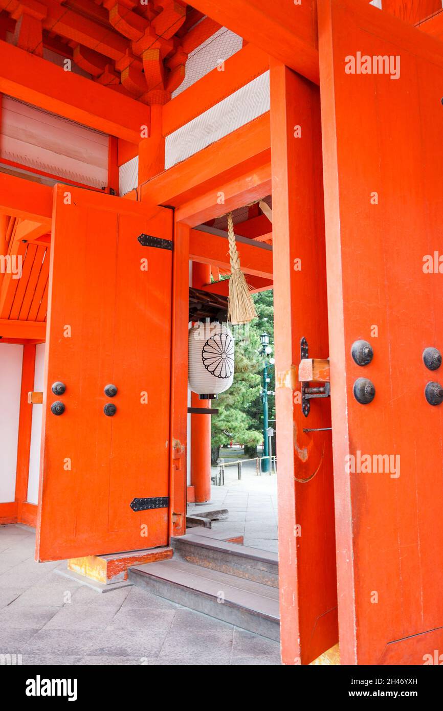 Vista della grande porta di legno arancione con lanterna bianca giapponese decorativa alla porta principale del Santuario Heian. Nessuna gente. Foto Stock