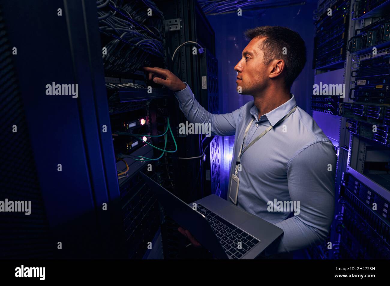 Tecnico IT maschile esperto che monitora le prestazioni del server Foto Stock