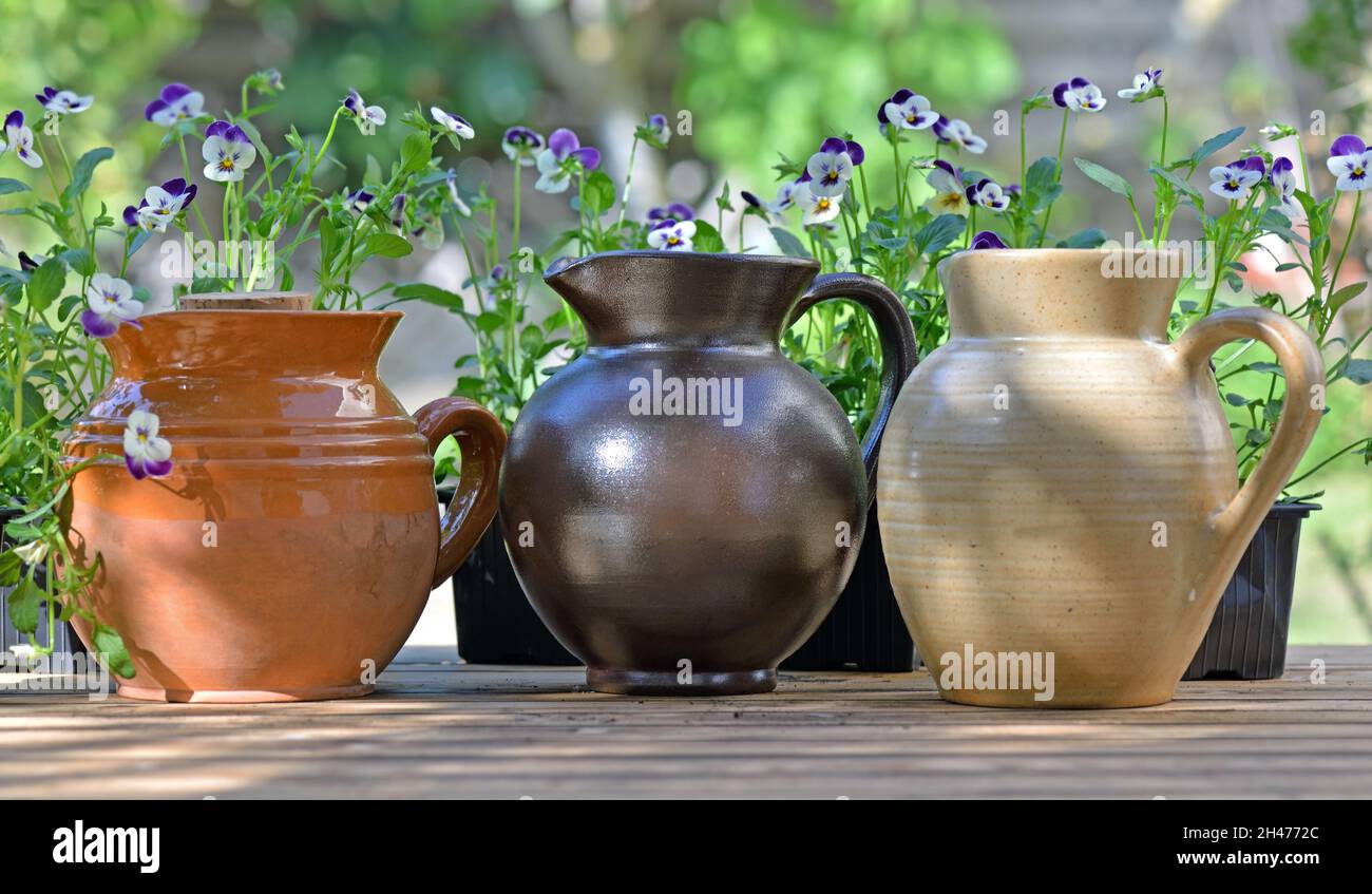 ceramica decorativa posta su un tavolo con fiori in giardino Foto Stock