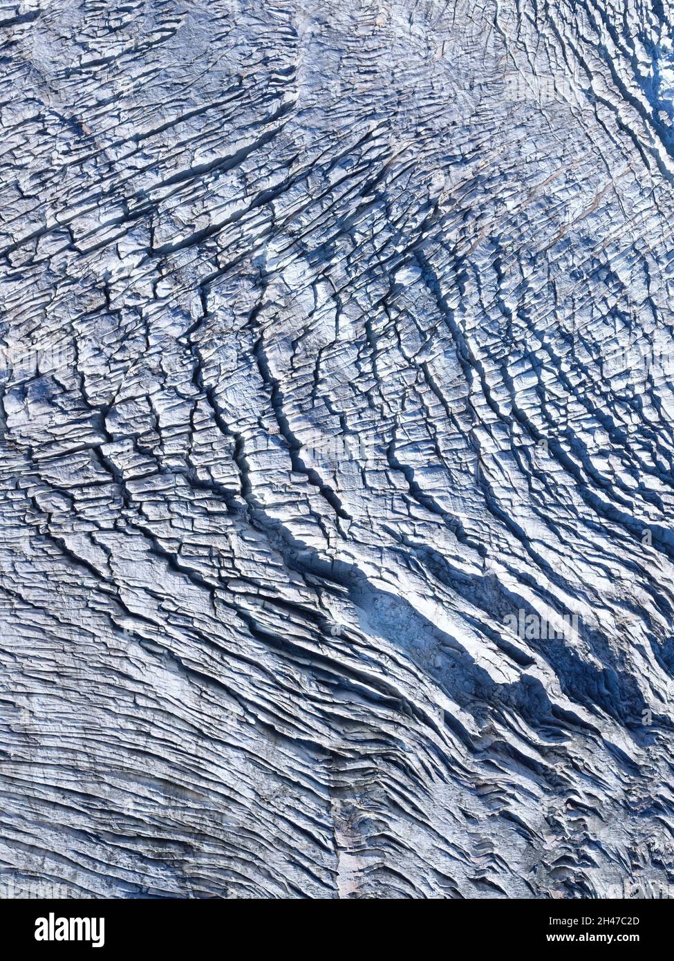 VISTA AEREA VERTICALE. Crepacci sulla superficie del ghiacciaio di Bossons nel mese di ottobre. Chamonix-Mont Blanc, alta Savoia, Auvergne-Rhône-Alpes, Francia. Foto Stock