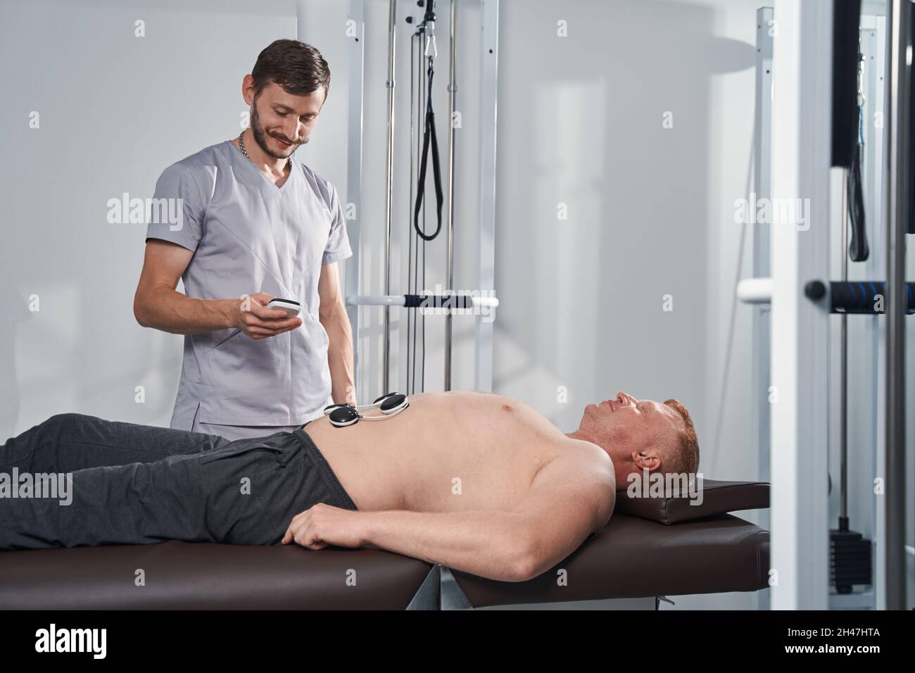 Il medico tratta l'uomo con stomaco di invalidità con elettrostimolatore  Foto stock - Alamy