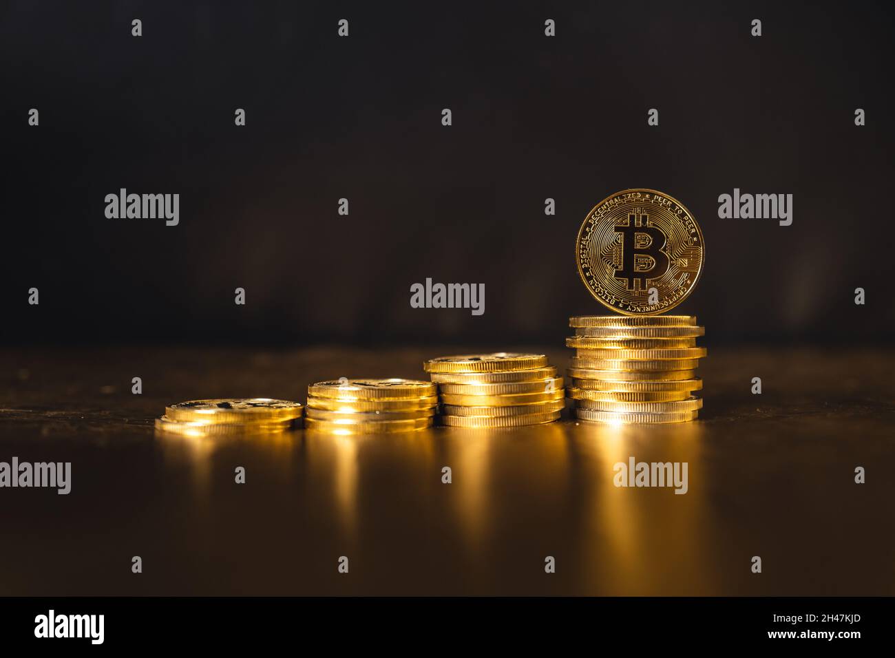 monete bitcoin impilate su sfondo oro nero Foto Stock