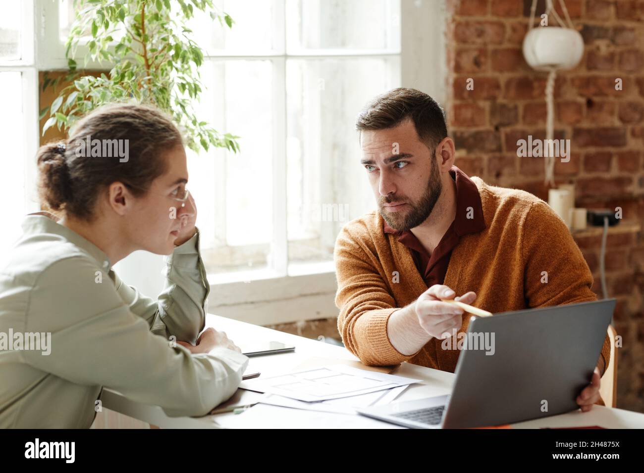 Ritratto di due persone creative che usano il laptop mentre discutono il progetto di design in studio, spazio copia Foto Stock