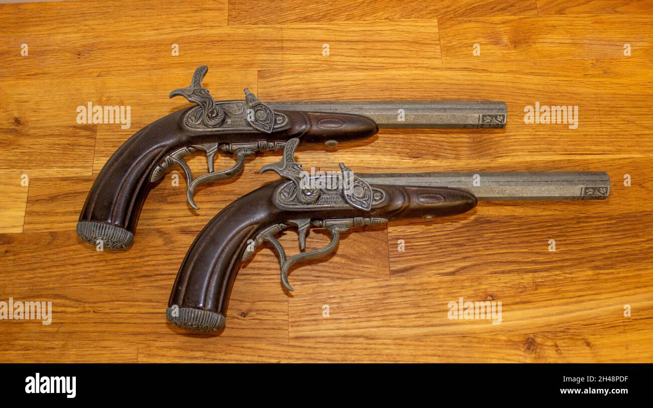 Vista dall'alto di due antiche pistole flintlock su un tavolo di legno Foto Stock